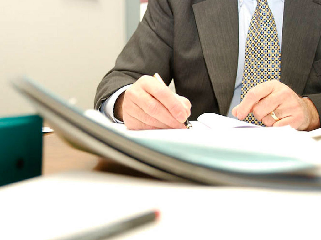 The man fills out the documents for the property Paperwork