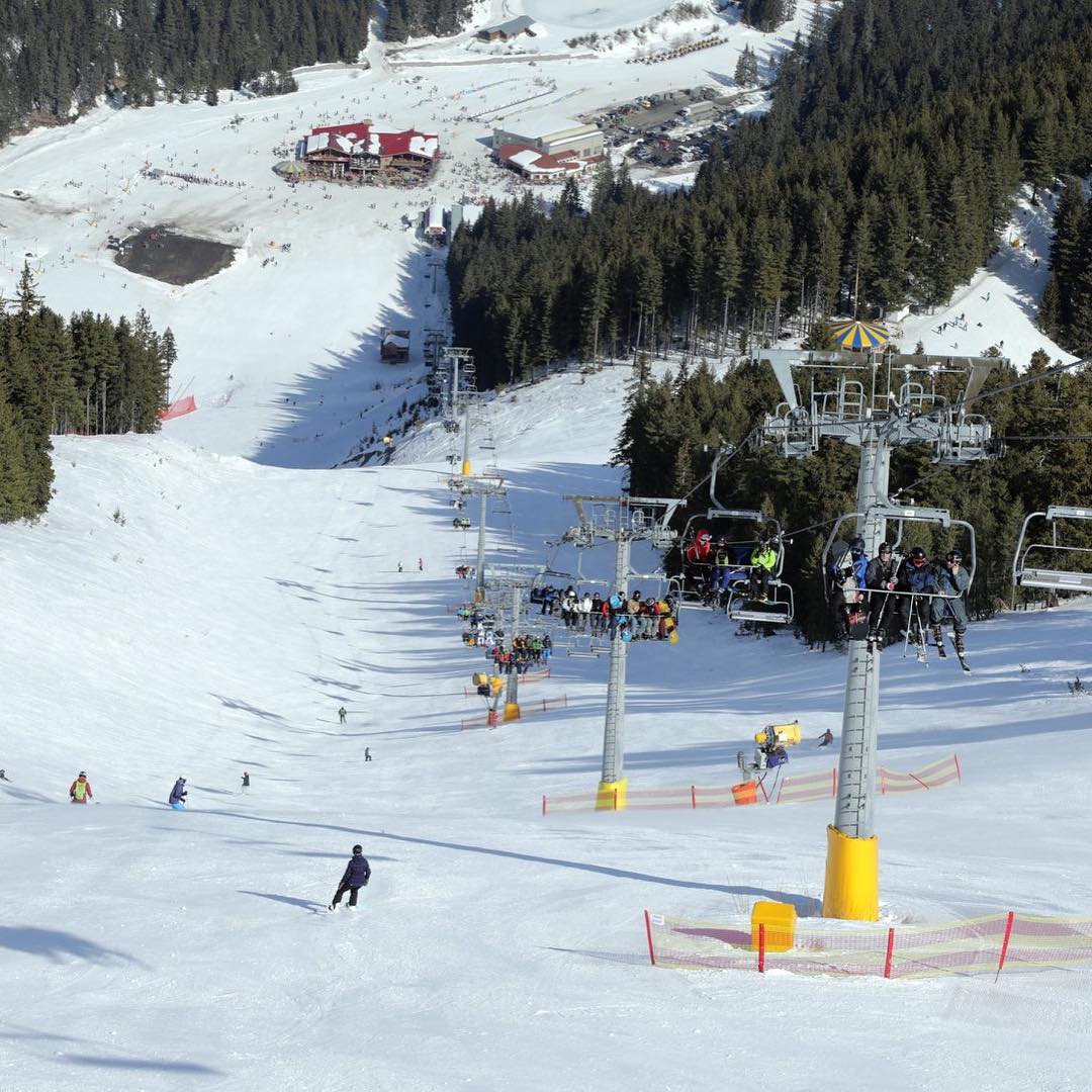 View of the ski slope: skiing and snowboarding on one side, chair lift on the other