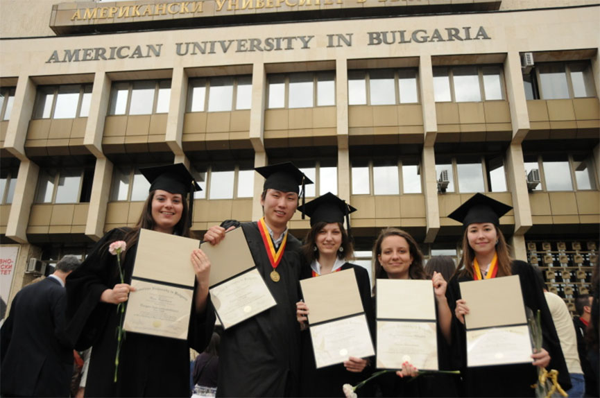 Joyful university graduates show their diplomas