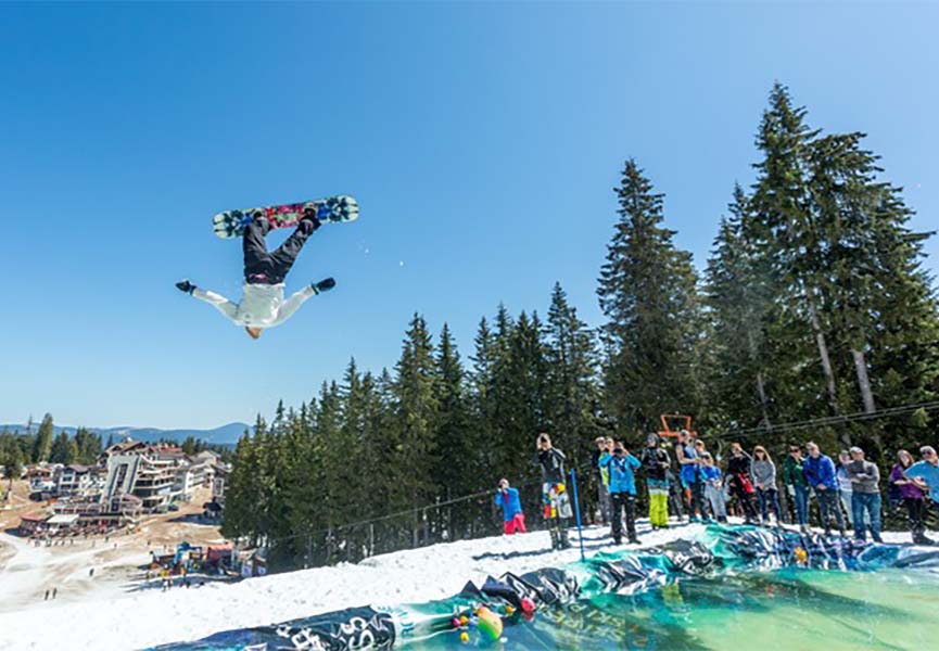 Snowboarder makes a water jump