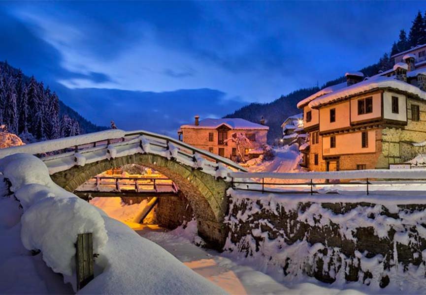 Snow-covered stone bridge in the village of Shiroka-Lyk