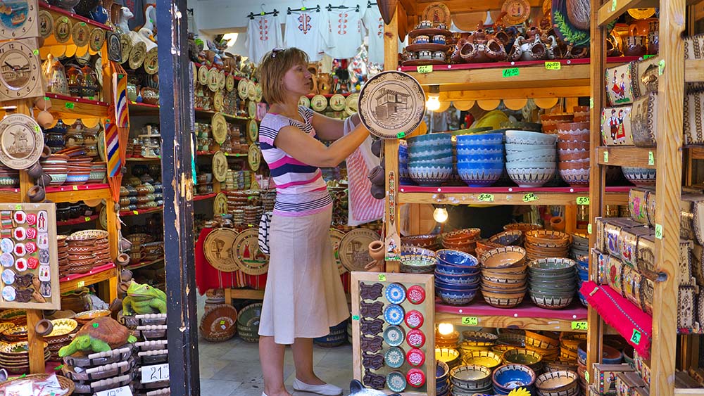 A young woman chooses souvenirs in Nessebar.