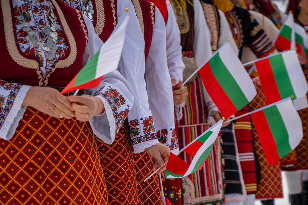 Women hold Bulgarian flags in their hands.