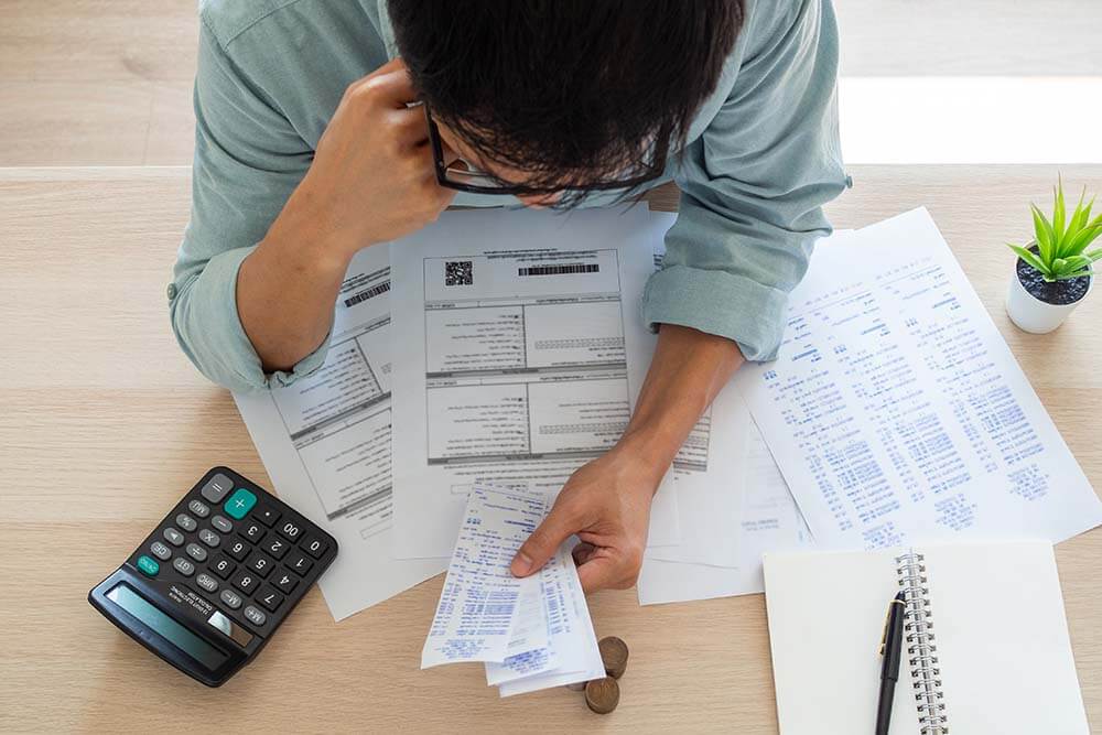 Person calculating monthly living expenses and budgeting for family relocation to Bulgaria using documents