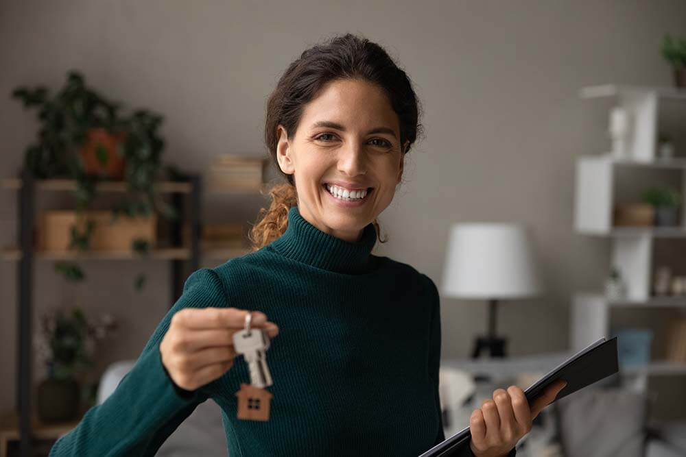 Woman holding keys and rental documents while preparing property for lease with tax benefits