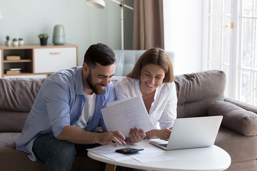 Planning annual property ownership costs together Couple reviewing mandatory annual property owner payments and planning budget adjustments at home