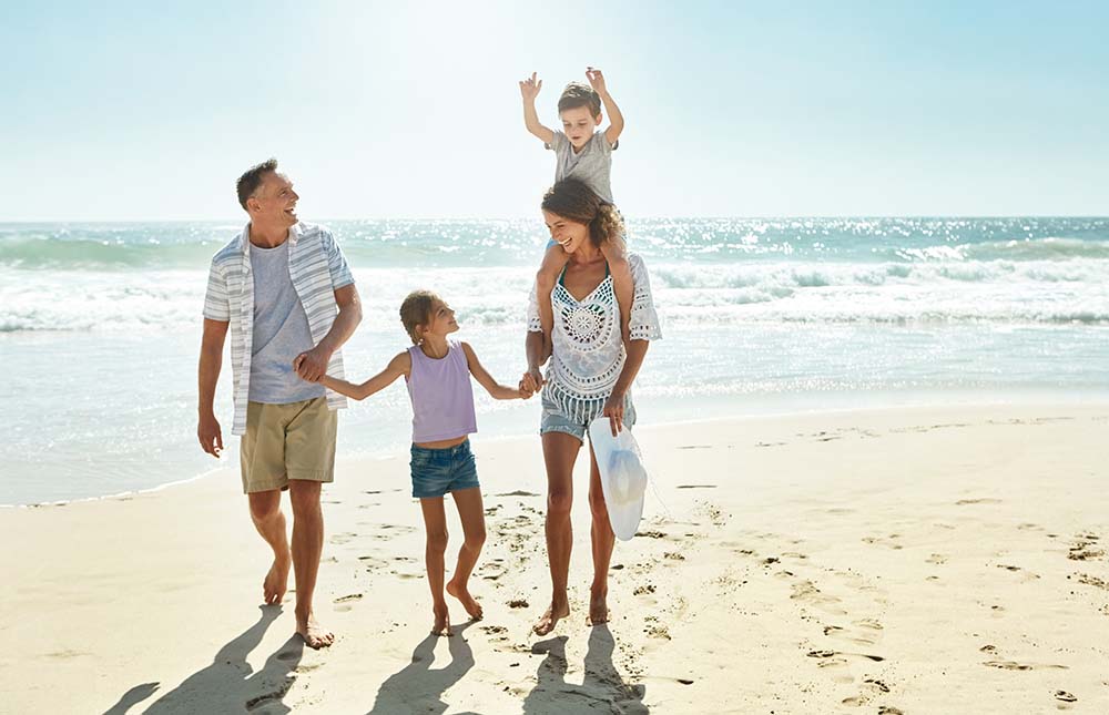 Irish family enjoying benefits of Bulgarian property ownership Happy Irish family with children enjoying successful property investment results on beautiful Bulgarian coastal beach during vacation