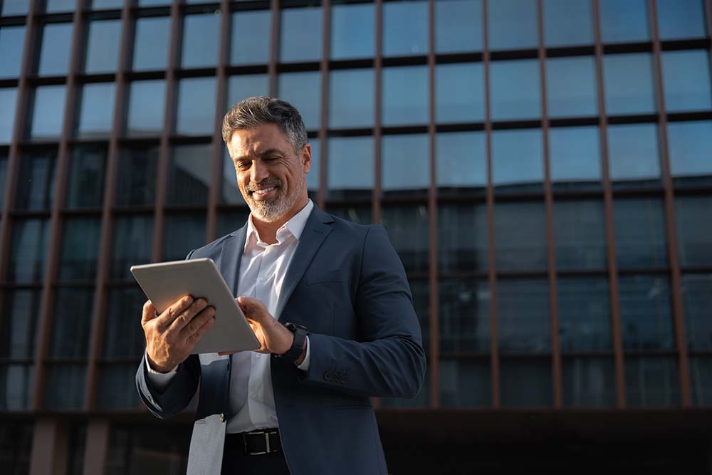 Irish citizen exploring mortgage options for foreign buyers in Bulgaria Irish businessman confidently researching Bulgarian mortgage lending options for foreign nationals using tablet outside modern banking building