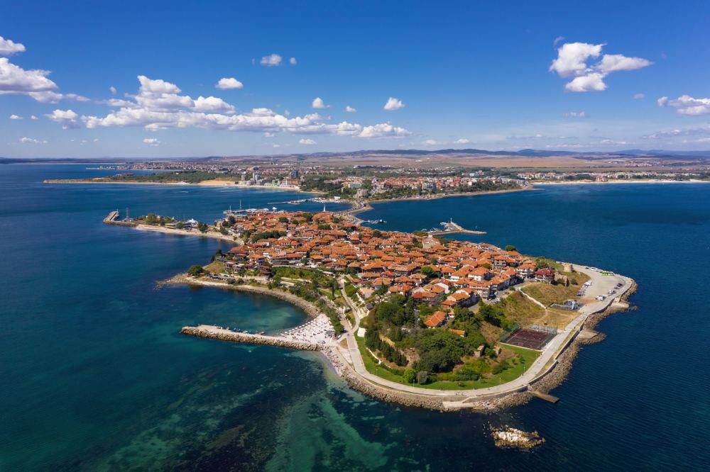Aerial photograph of an ancient coastal peninsula town in Bulgaria, highlighting the cultural context of property transactions