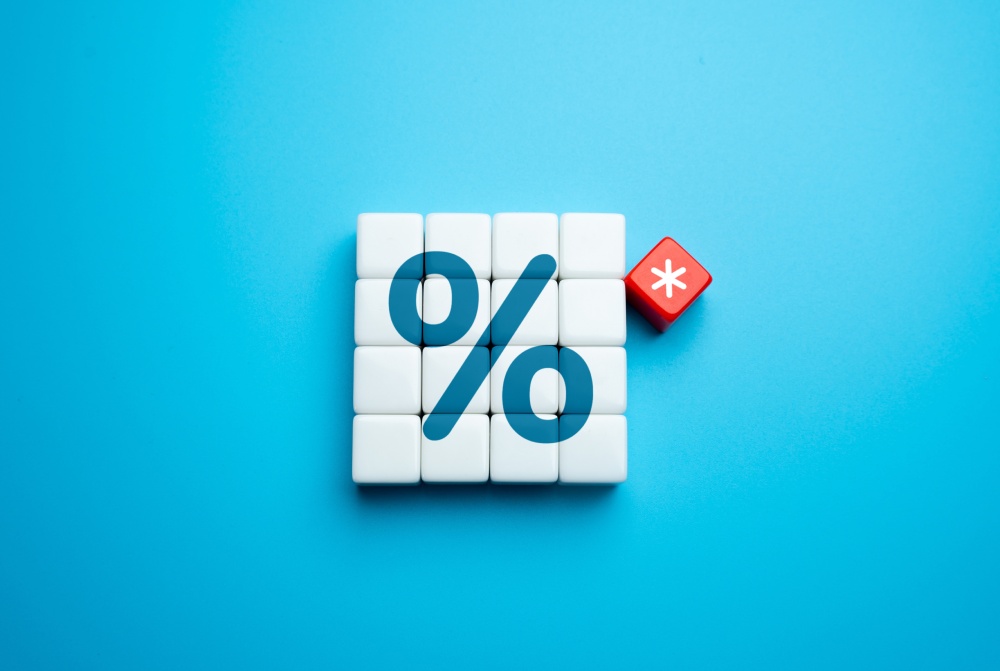 Graphic with a large percentage sign and a red risk cube, illustrating the conditions and difficulties of a mortgage in Bulgaria