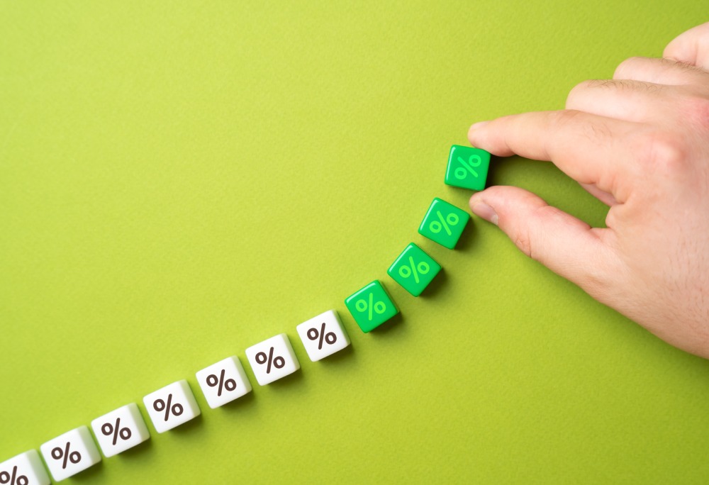 A hand moves green cubes with percentage signs, representing the complex tax calculation Netherlands – Bulgaria