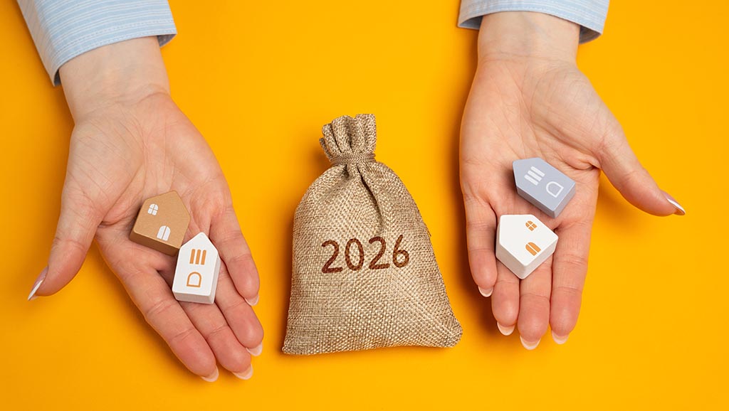 Hands hold house models and a money bag, reflecting the financial aspects of buying property in Bulgaria