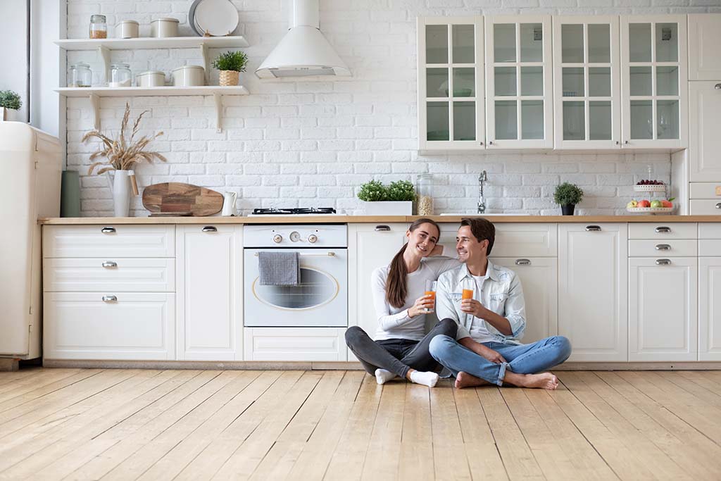 A couple sits on the floor of their new bright home, enjoying the moment after property purchase in Bulgaria